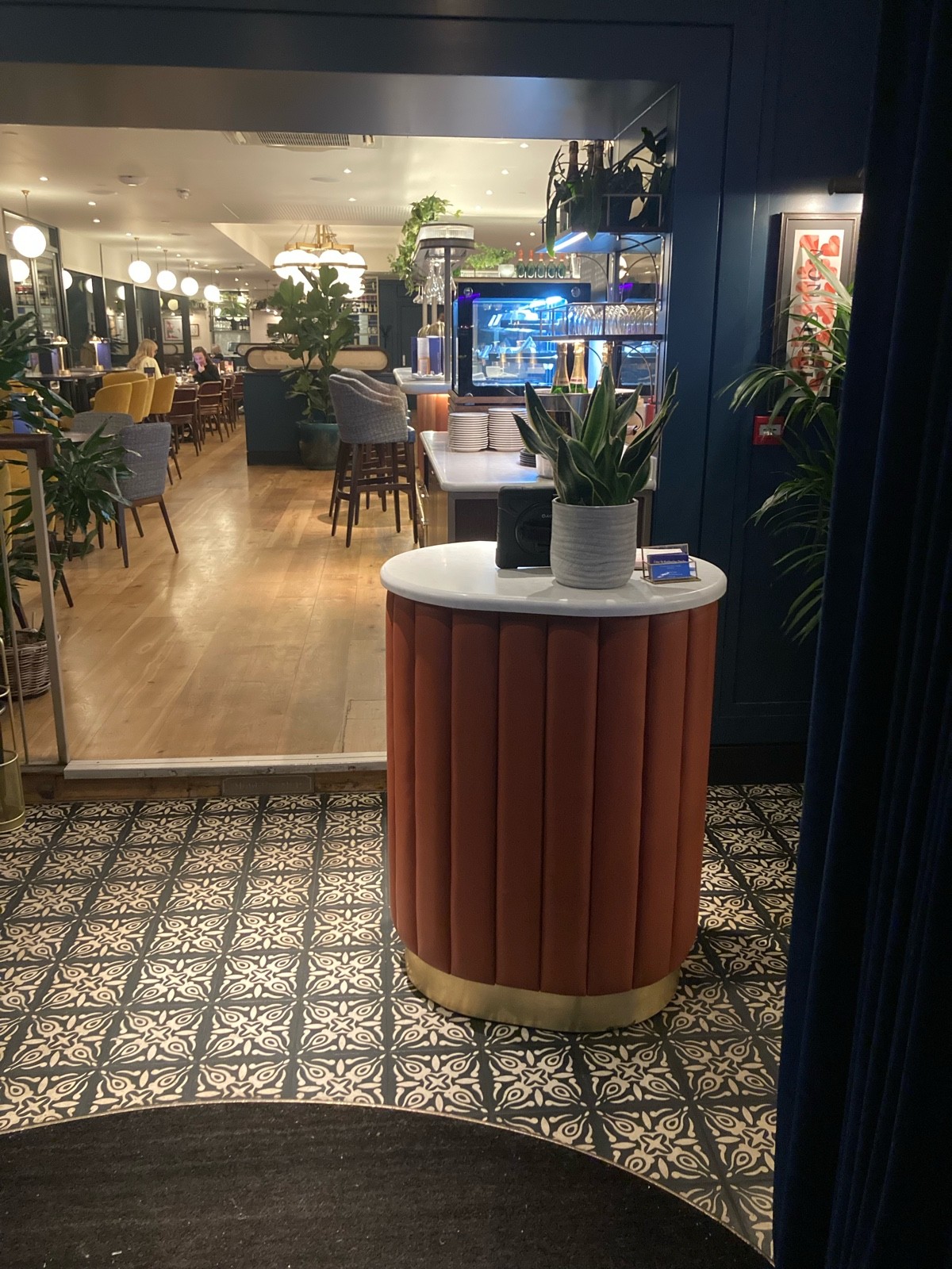 From entrance facing straight. Standing height welcome desk ahead. Waiting area on left.