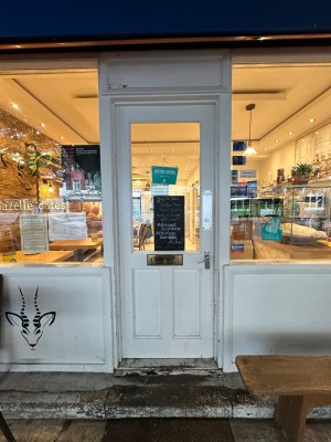 White and glass panelled door with silver handle to right of door. Push to open.