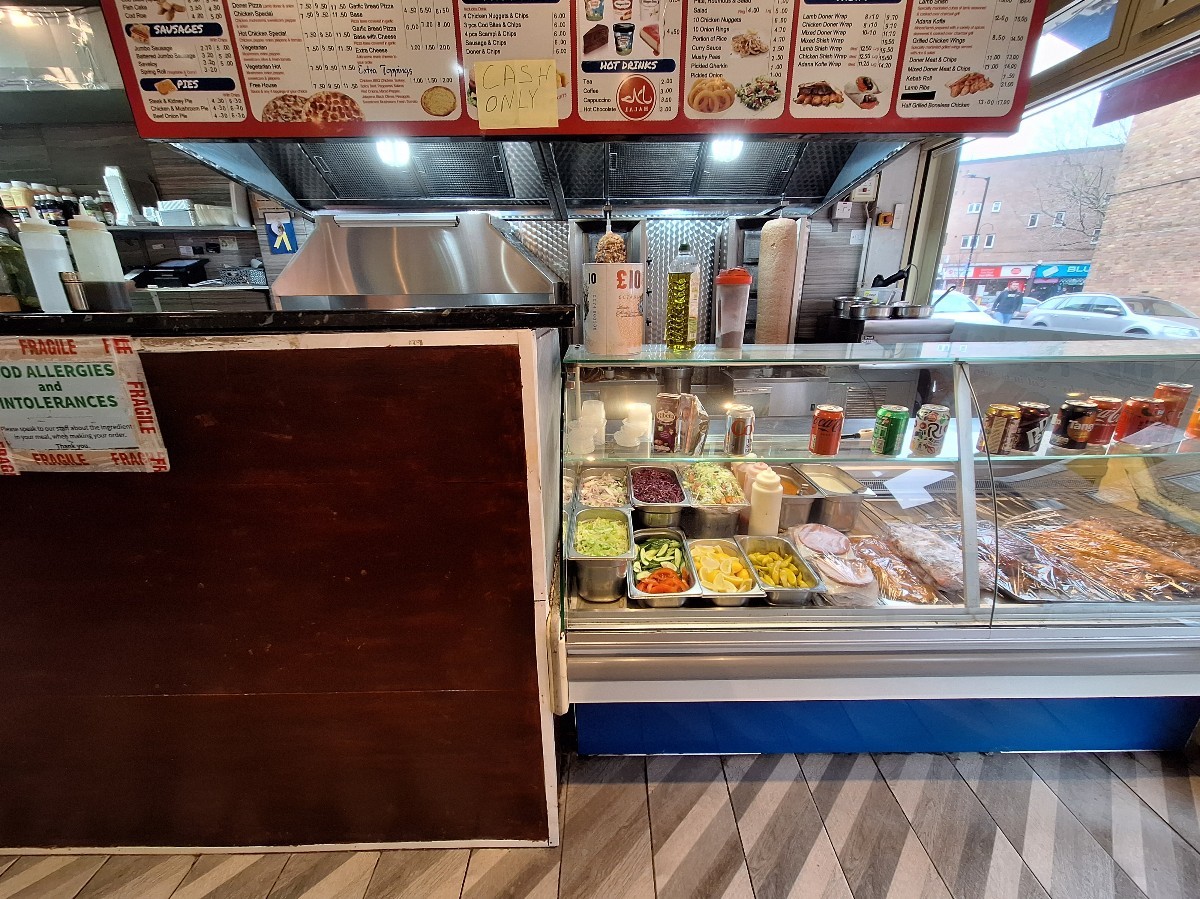 From entrance facing right. Display counter ahead. Open kitchen behind.