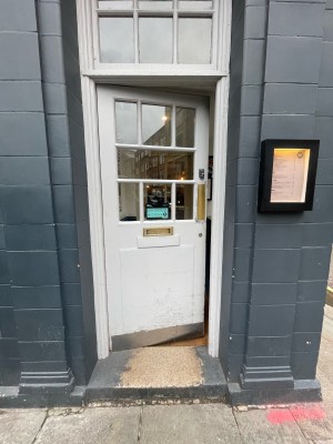 White wooden and glass door ahead. Push from right to open.