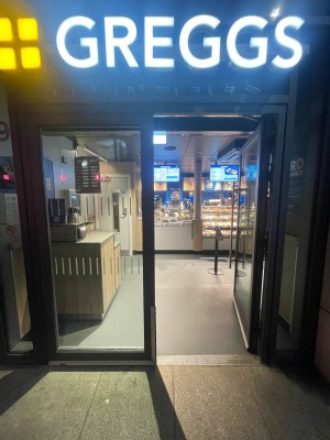 Glass doors with black frame ahead. Push silver metal handles in centre to open.