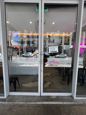 Glass doors with grey metal frame and silver handle in middle. Slide open.