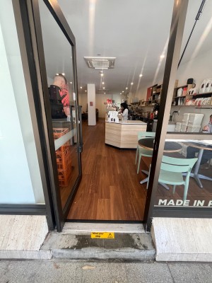 Glass door with brown metal frame. Push from right.