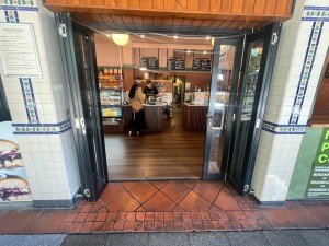 Glass door with black metal frame folds open to left.