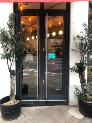 Glass doors with black frame. Push handles in centre to open.