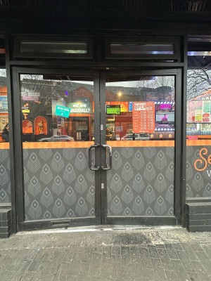 Glass doors with black frame ahead. Push black metal handles in centre to open.