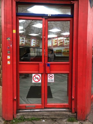 Glass doors with red frame. Push handles in centre to open.