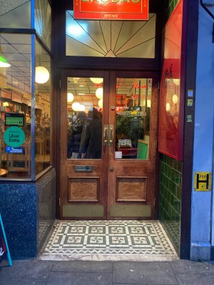 Opening ahead to glass doors with wooden frames ahead. Pull doors to open via handles in center.
