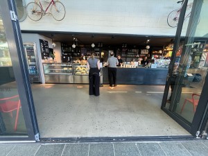 Glass door with grey metal frame folds open to right.