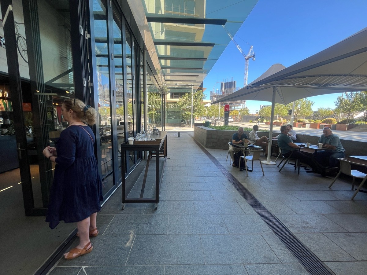 From entrance facing right. Water stand on outer wall. Table and chairs ahead to right ahead. Half booths further to right