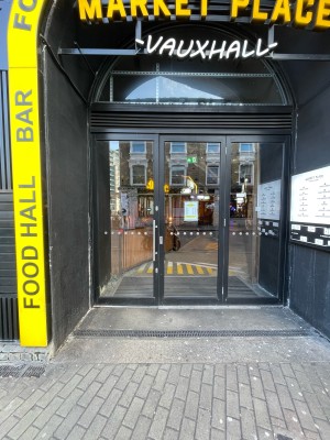 Black metal-framed glass door ahead. Pull silver handle from left to open.