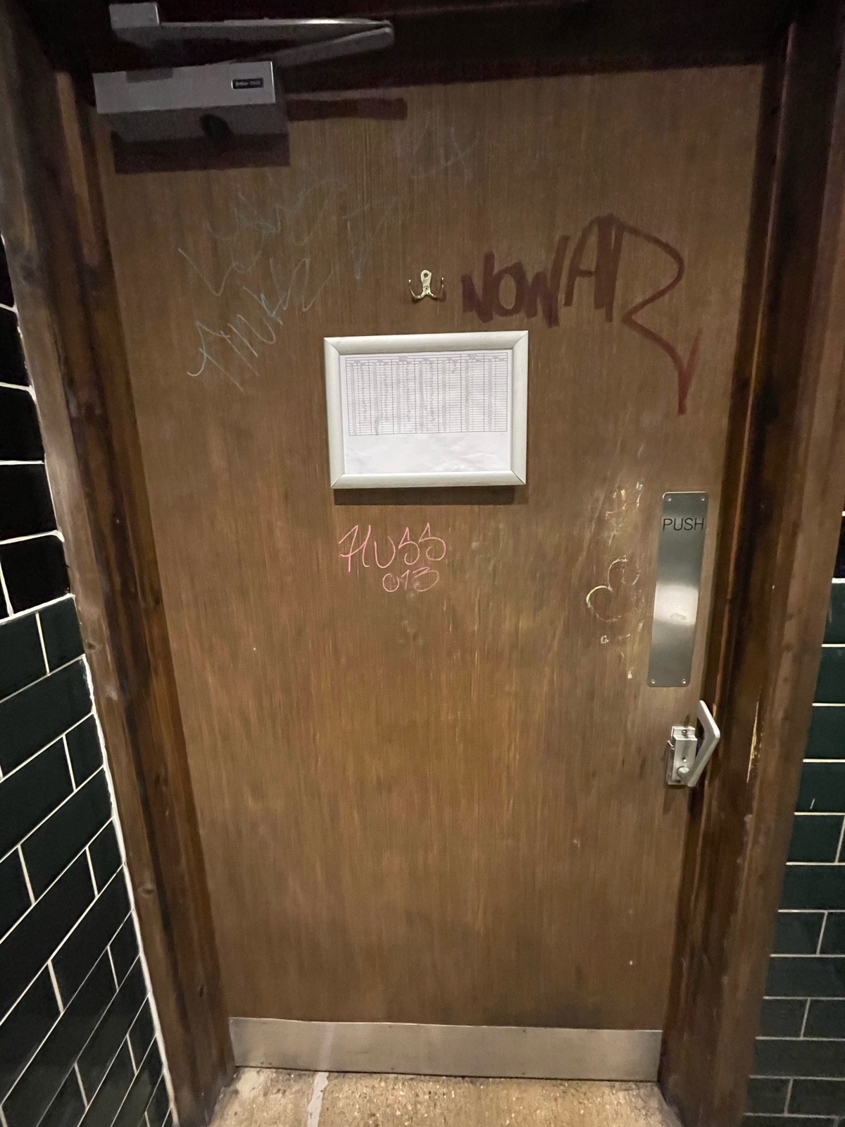 Back of toilet door. Push on right to open.