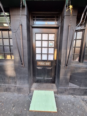 Black door with glass panel ahead. Push on right to open. One step up to door. Ramp on request.