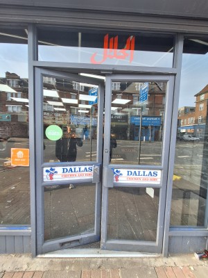 Glass doors with grey frames ahead. Push in centre to open.