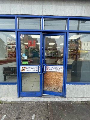 Glass doors with blue frame ahead. Push blue metal handles in centre to open.