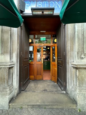 Brown doors with gold handle to centre of left-hand door. Push to open.