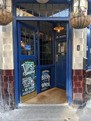 Blue wood and glass doors with metal handles in centre. Push to open. Doorbell right of doors.