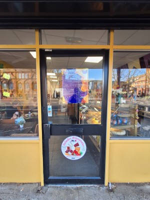 Glass door with black frames ahead. Push on left to open.