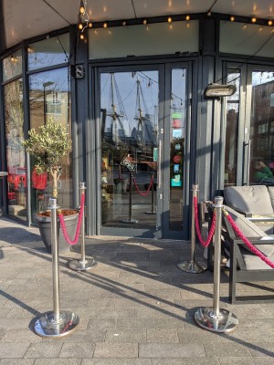 Rope barriers along left and right, door to venue ahead.