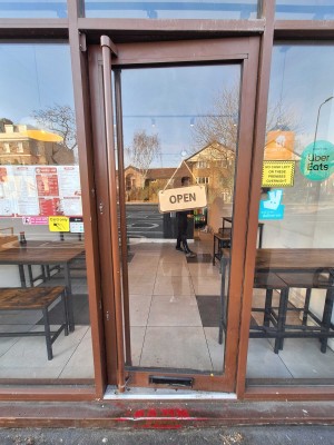 Glass door with brown frame ahead. Push door to open from left.