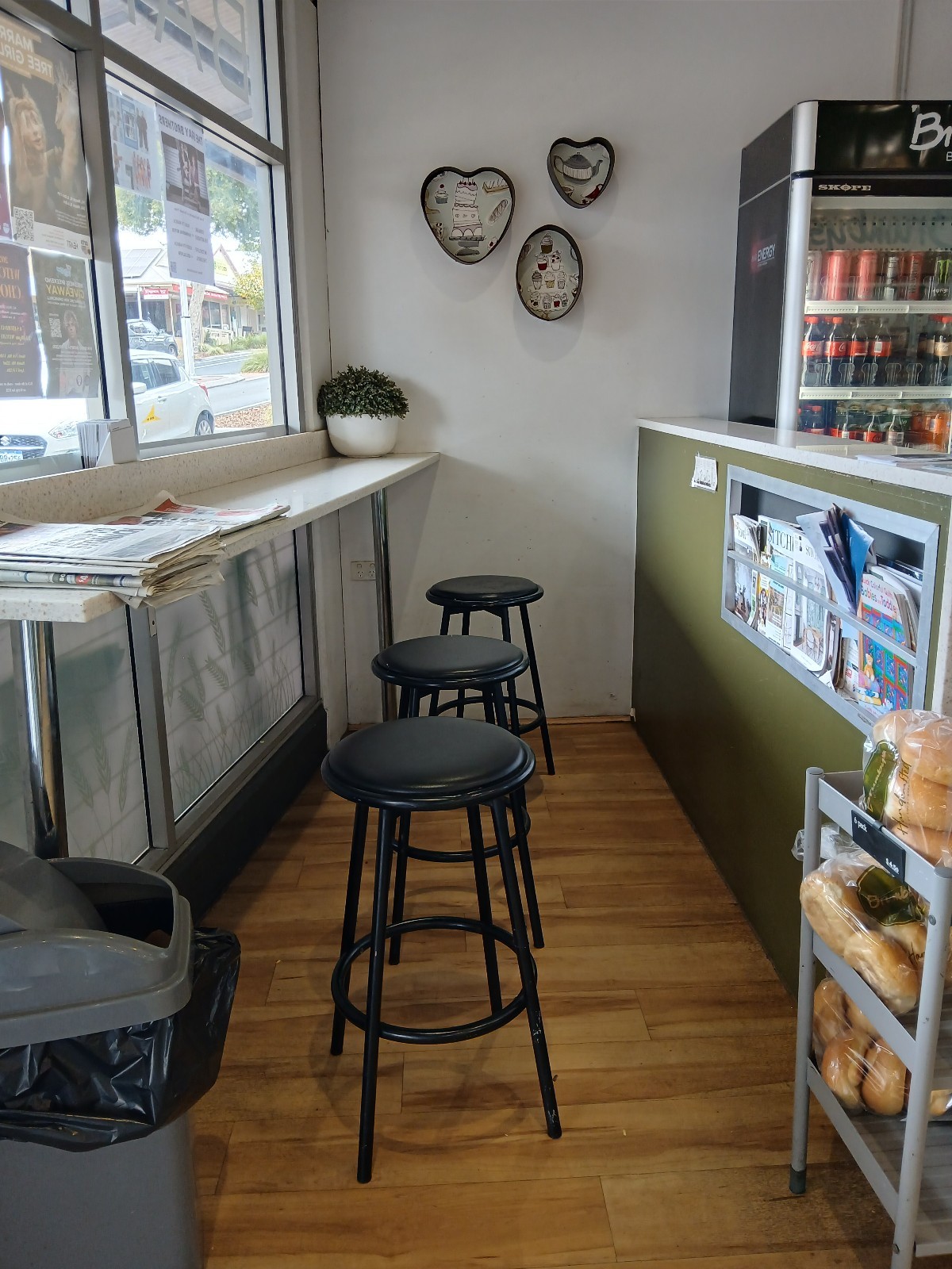 From entrance facing left. High table and backless stools along left ahead after bin.