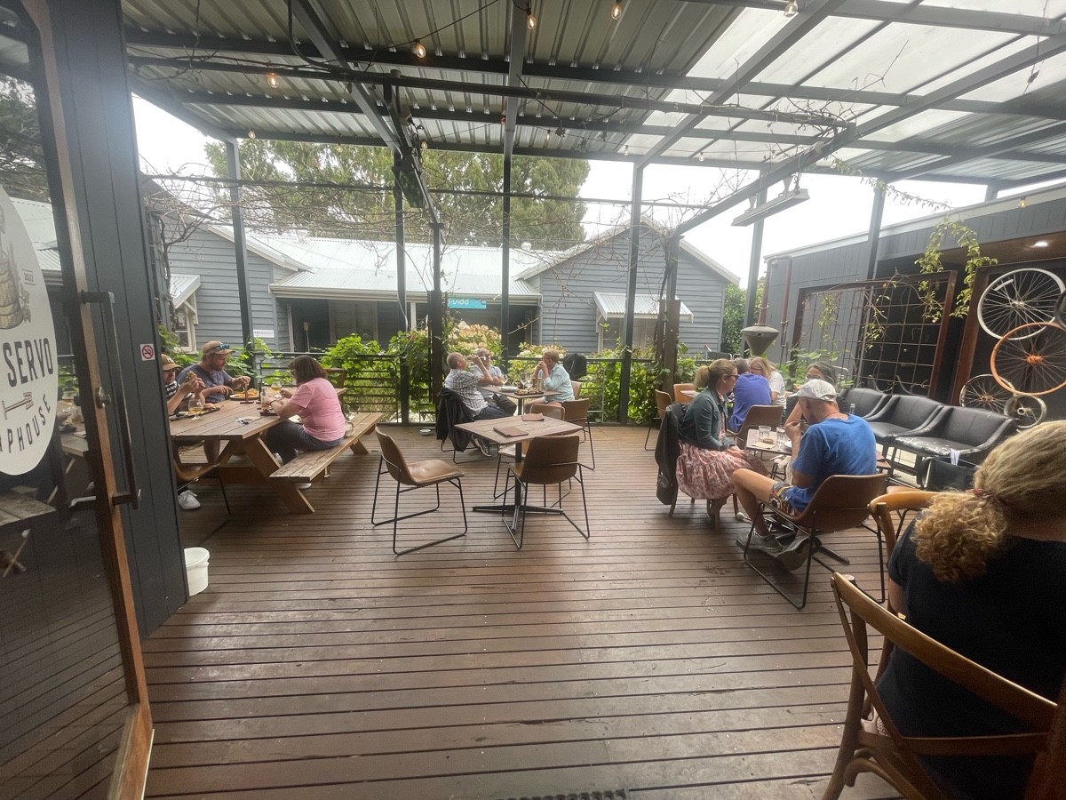 Outdoor decked area with cafe table and chairs as well as picnic table.