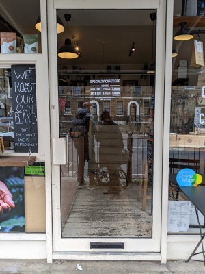Glass door with white frame. Pull white handle from left to open.