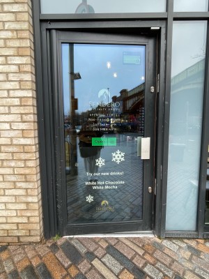 Single glass door with black frame. Push sliver handle on left to open.