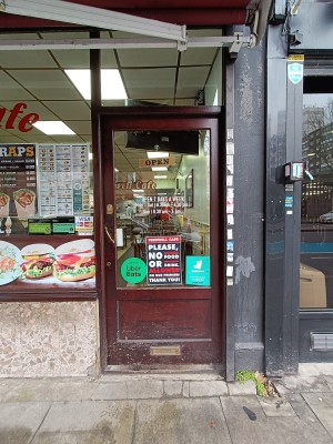 Glass door with brown, wooden frame. Push golden handle on left to open.