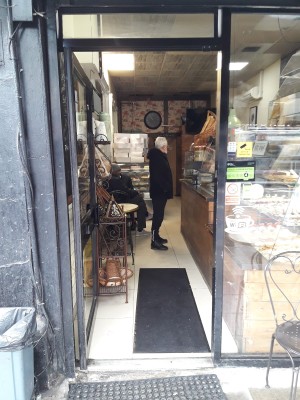 Glass door with black frames. Push on right to open.