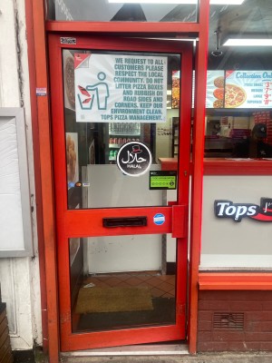 Glass door with red frame ahead. Push door to open via handle on right.