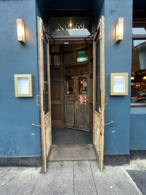 Wooden doors with glass panels ahead. Pull brass handles in center to open.