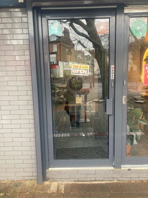 Glass door with grey frame ahead. Pull door to open from right.