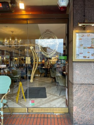 Glass door with no frame. Push brass handle on left to open.