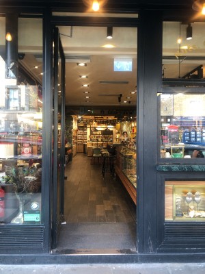 Glass door with black frame. Push from right to open.