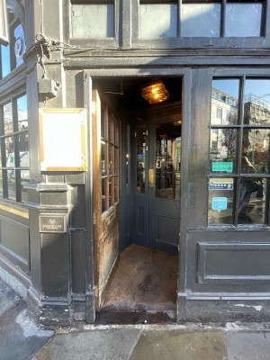Wooden door with glass panels ahead. Push on right to open.