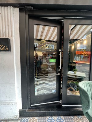 Glass door with black frame. Push silver handle from right to open.