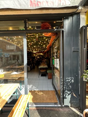 Glass door with grey frame. Push gold handle from left to open. Seating to left.