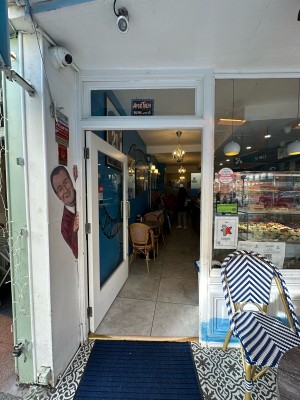 Glass door with white frame. Push gold handle from right to open.