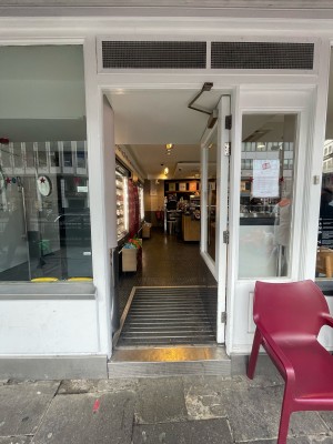 Glass door with white frame ahead. Push from left to open.