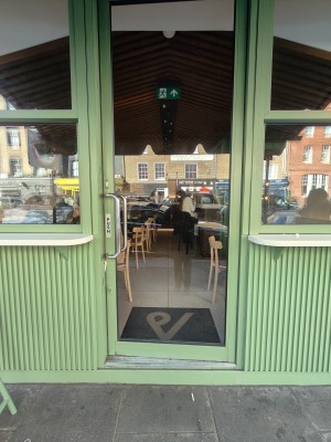 Green framed glass door. Push silver handle on left to open.