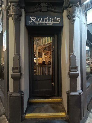 Glass door with grey frame ahead. Pull to open via metal handle on right.