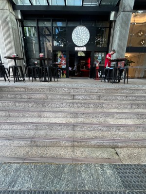Steps up to entrance. Tactile flooring both ends.