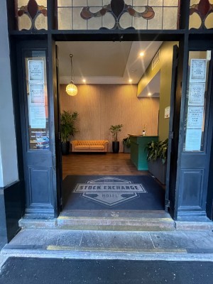 Glass double doors with gold handle on right door. Push to open.