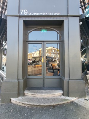 Two steps up to grey framed glass doors. Push from centre to open.