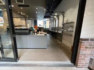 Glass doors with black metal frame fold open to left.