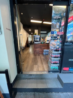Glass door with silver handle on right. Push from right.