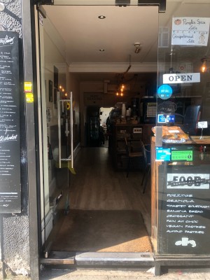 Glass door ahead with silver metal handle on right. Push to open.