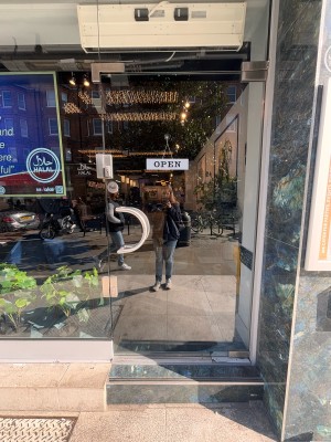 Glass door ahead. Pull metal handle at center left to open.