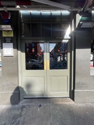 Glass paneled doors with light green frame. Push in center to open.